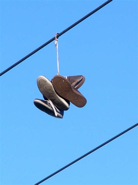 tennis shoes over power lines|sneakers on telephone wire meaning.